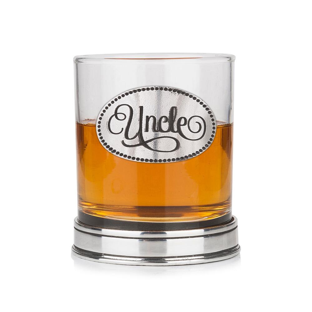 Whisky tumbler with pewter 'Uncle' badge and polished base, partially filled with amber liquid