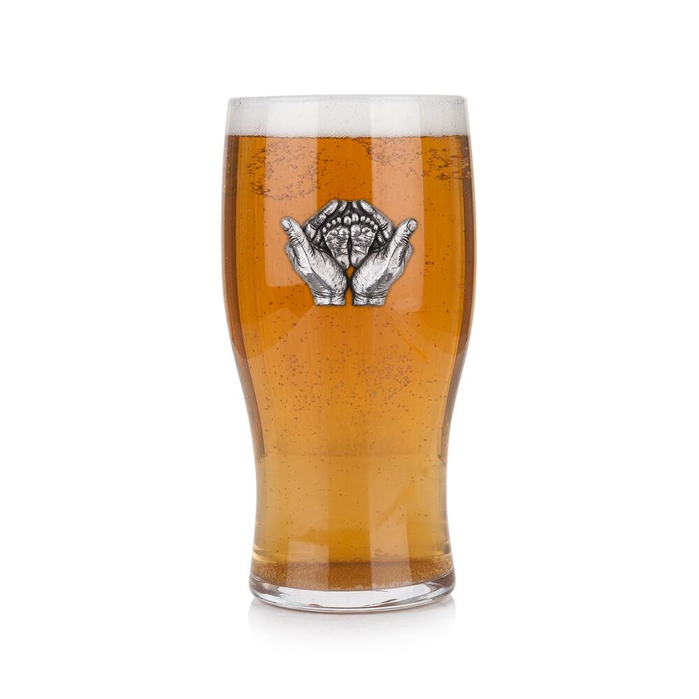 Pint glass with handmade pewter “New Baby” badge, filled with golden beer