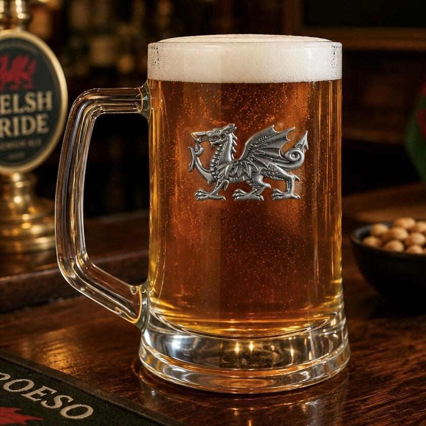 A Beer Tankard with a Pewter Welsh Dragon badge on the front, filled with Amber Beer