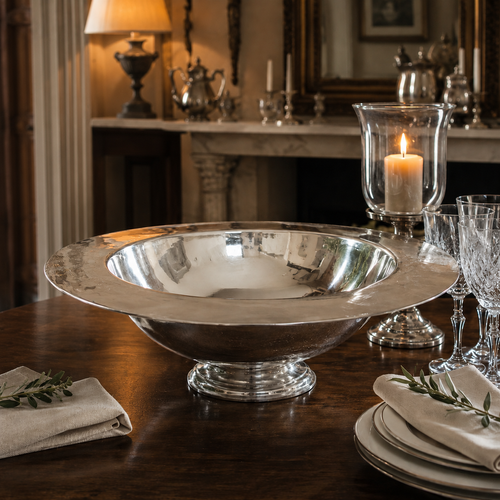 Handcrafted pewter 19 inch broad rim footed bowl with polished hammered finish, luxury pewter table centrepiece displayed on an elegant dining table with crystal stemware, candlelight and traditional décor