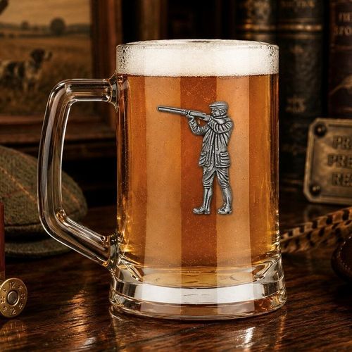 A Beer Tankard with a Pewter Shooting badge on the front, filled with Amber Beer