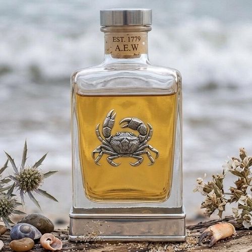 Handcrafted glass hip flask with pewter base featuring detailed crab emblem on front