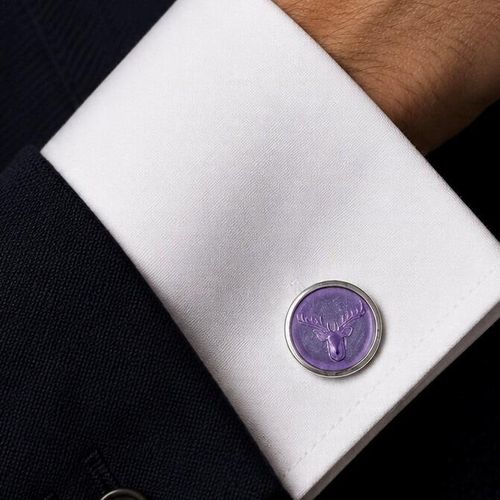 Close-up of handcrafted pewter cufflinks featuring a detailed stag head embossed with transparent lilac enamel
