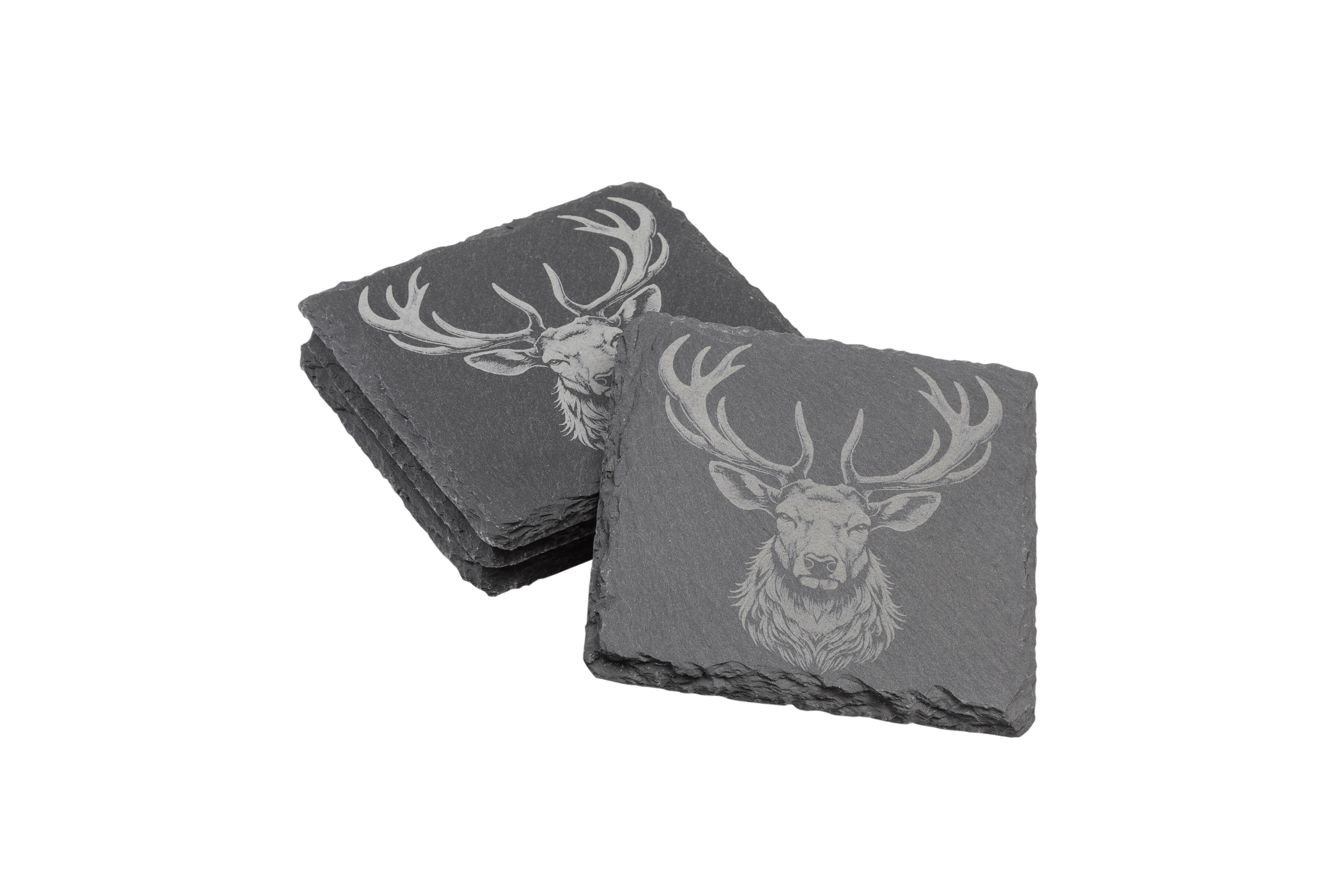 Two stacks of square slate coasters, each engraved with a detailed Stag design.