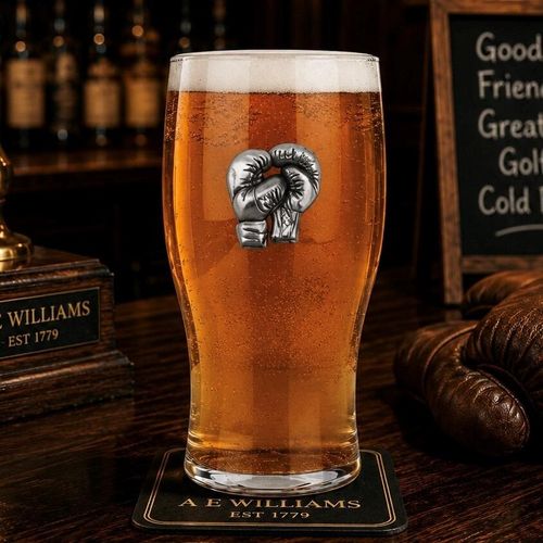 Pint glass with handmade pewter boxing badge featuring boxing gloves and fighter stance filled with golden
