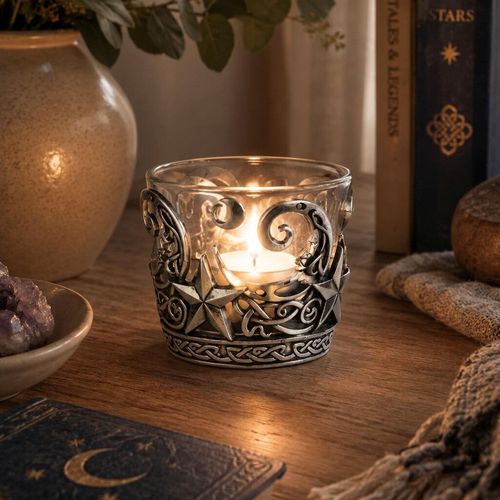 Pewter and glass tealight candle holder featuring an intricate celestial design with crescent moons, stars, and Celtic knotwork bands