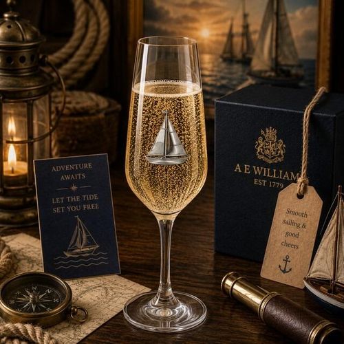 A Champagne Flute with a Pewter Sailing badge on the front, filled with Champagne