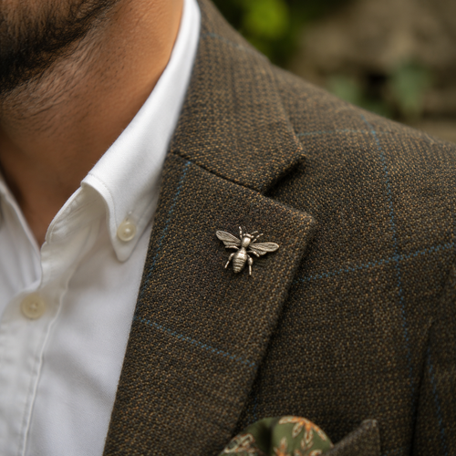 A pewter honey bee lapel pin on a tweed jacket