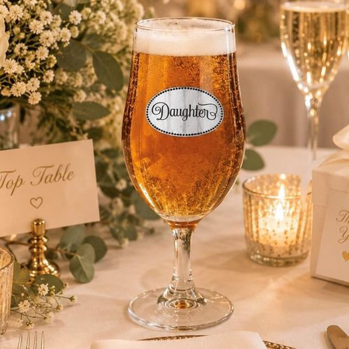 A Stemmed Pint Beer Glass with a Pewter Daughter badge on the front, filled with Beer