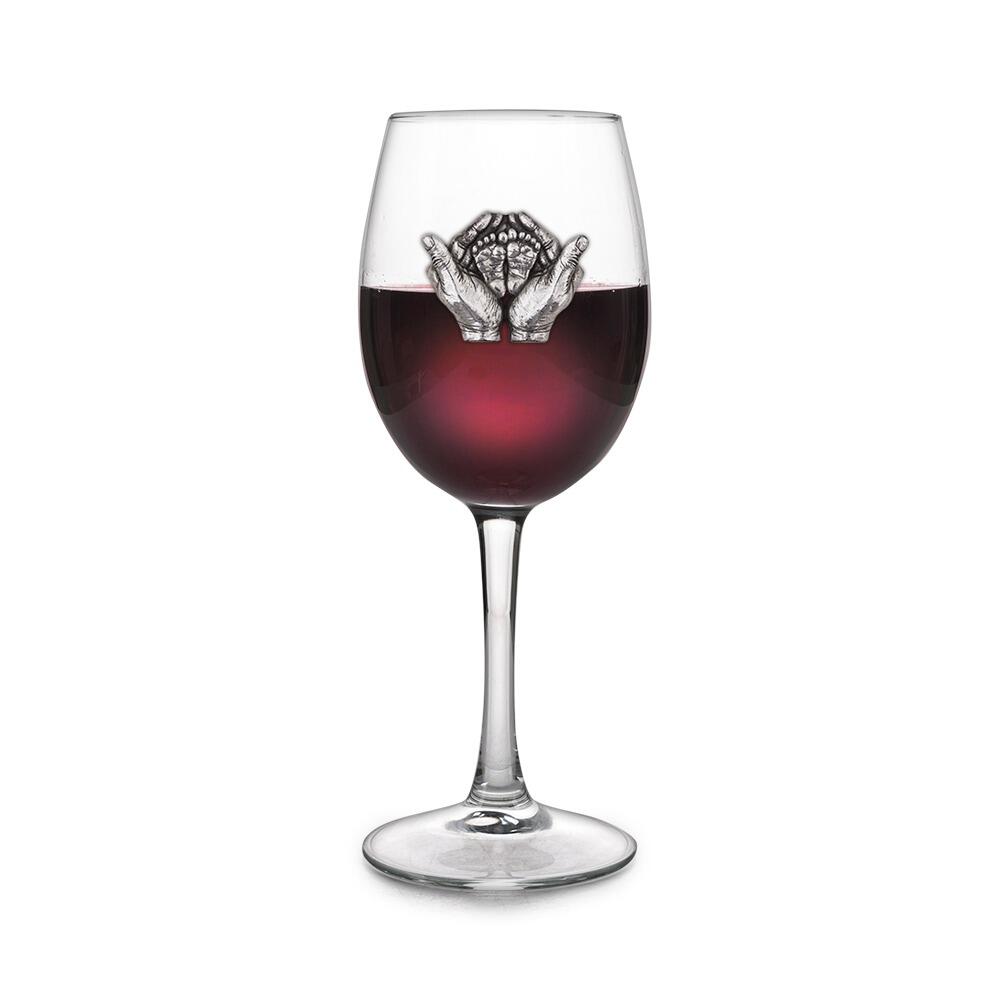 Wine glass with handmade pewter new baby badge filled with red wine