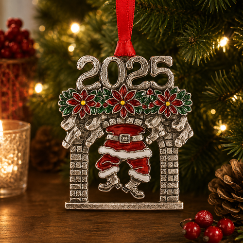 Handcrafted pewter 2025 Christmas ornament featuring Santa Claus climbing down a chimney beneath poinsettias, hanging on a festive Christmas tree with warm holiday lights and seasonal decorations.