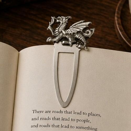 Handcrafted pewter Welsh dragon metal clip bookmark resting on open book page