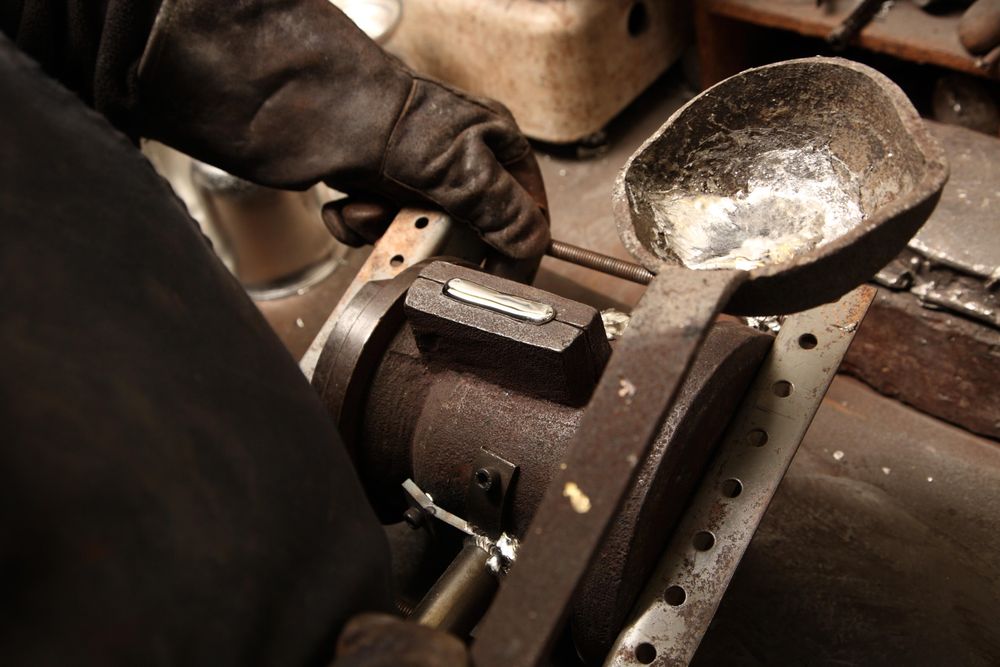 Pouring molten pewter into a bronze mould