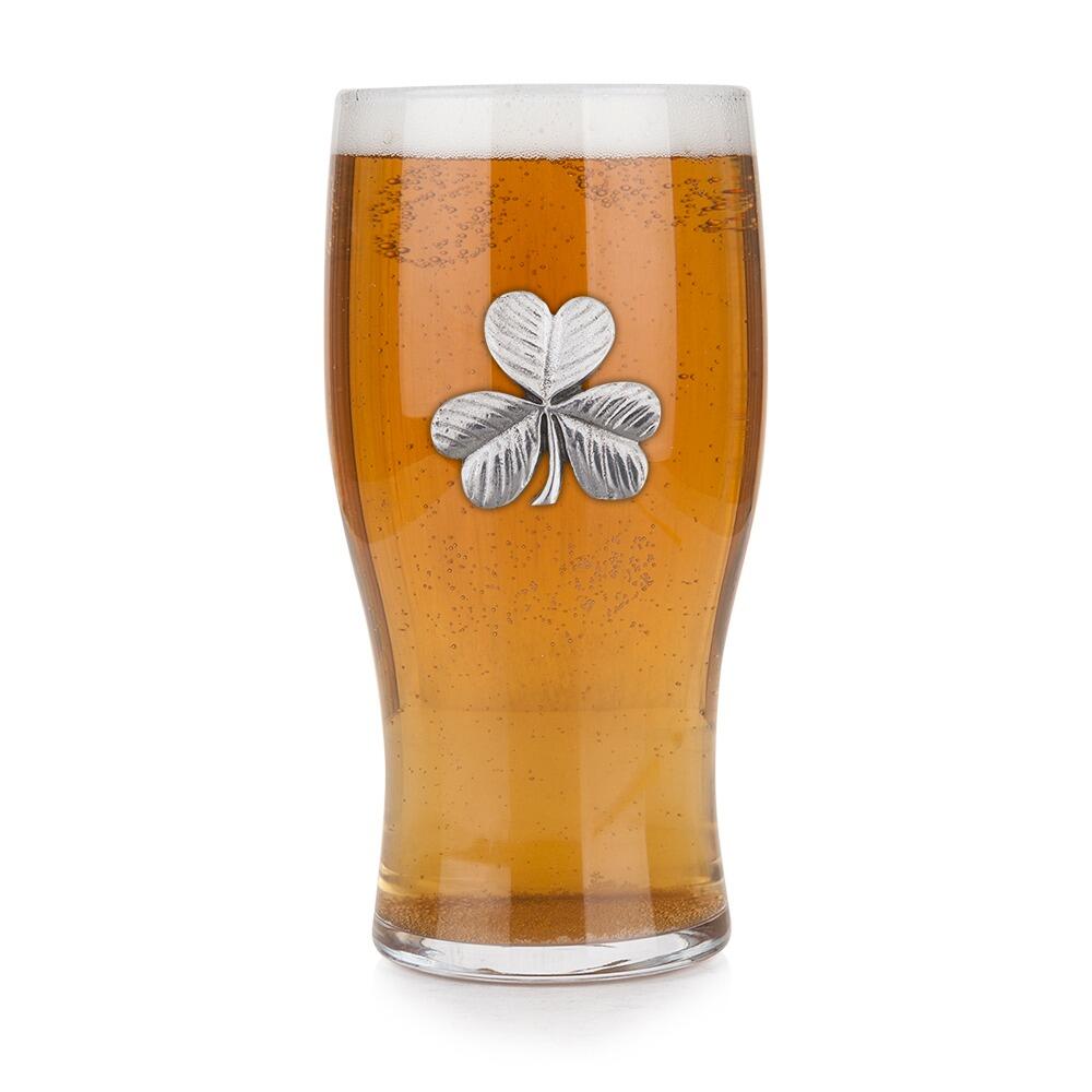 Pint glass with handmade pewter shamrock three-leaf clover with Celtic styling badge filled with golden beer