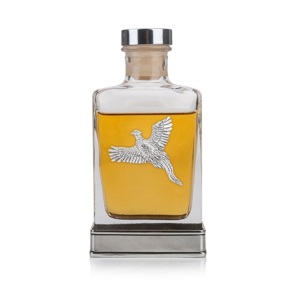 A glass flask with a pewter base and a handcrafted pewter pheasant emblem on the front