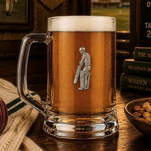 A Beer Tankard with a Pewter Cricketer badge on the front, filled with Amber Beer
