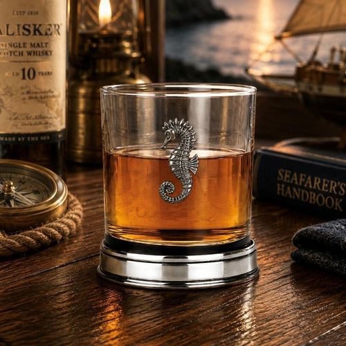 Whisky tumbler with pewter seahorse motif and polished base, partially filled with amber liquid