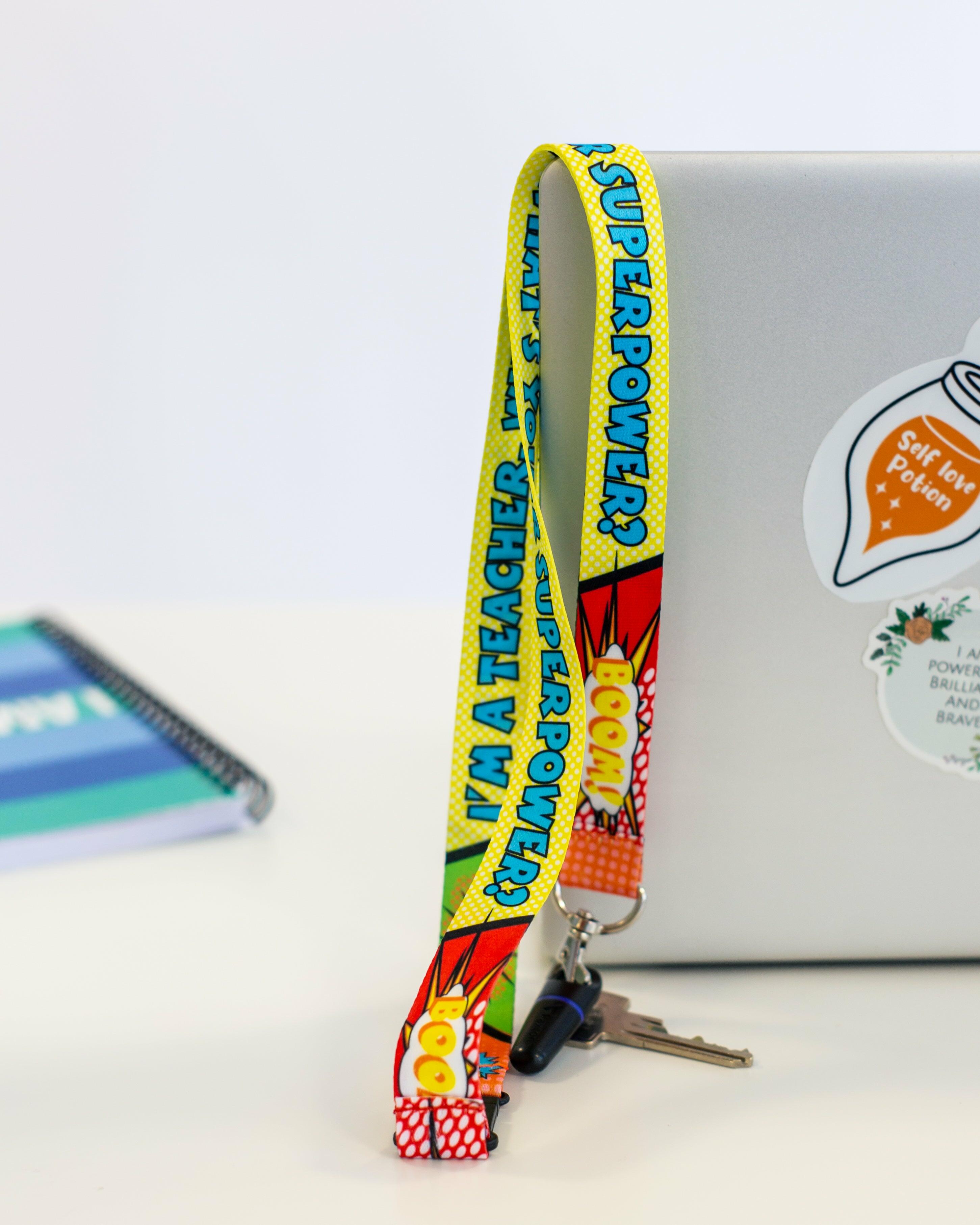 ‘I’m A Teacher, What’s Your Superpower’ lanyard hanging over the edge of a desk with keys attached