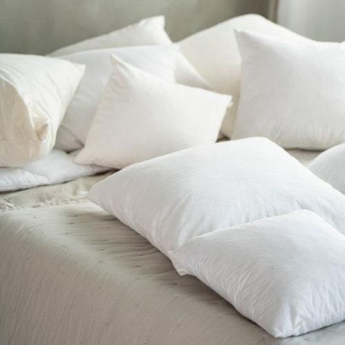 cushion pads and inserts scattered on a bed