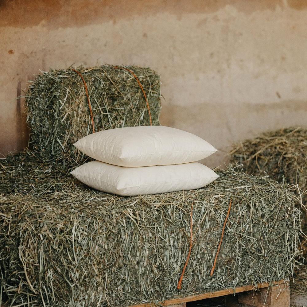 Square wool cushion inserts styled on a hay bale