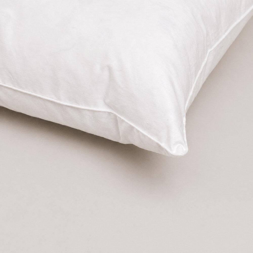 Close-up of a white pillow corner with stitched edging