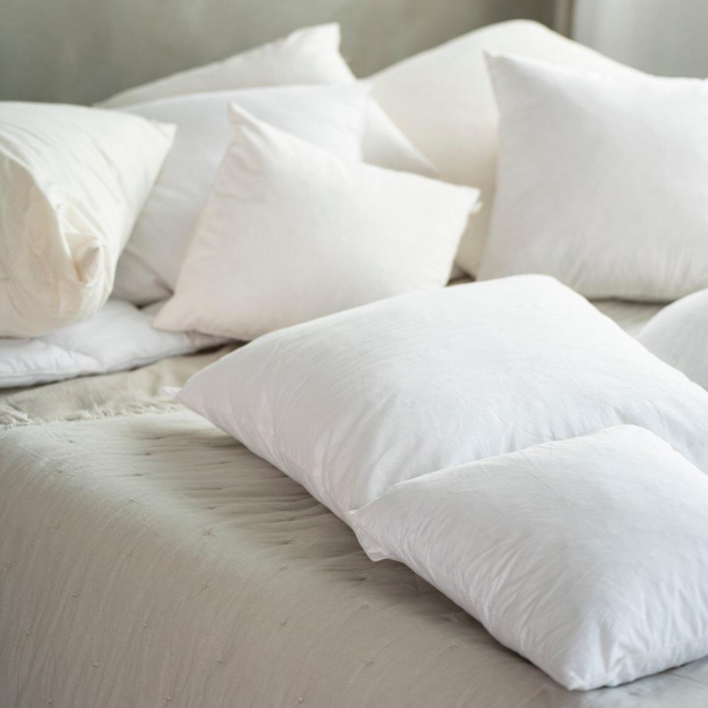 Square cushion pads scattered on a bed