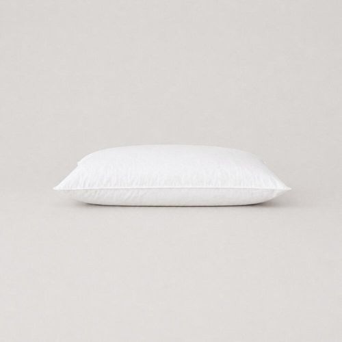 White cot pillow with top-stitched edges lying flat