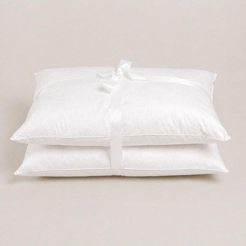 Pair of white eco fibre pillows tied with ribbon