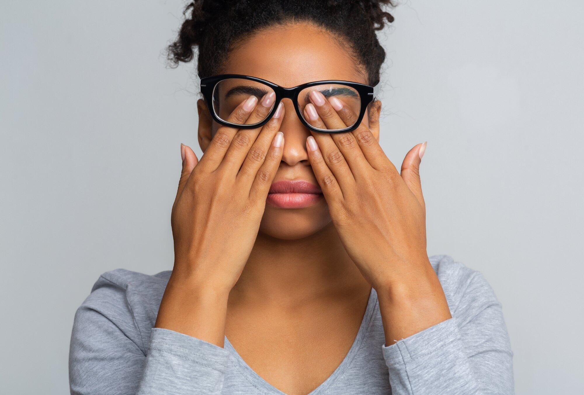 Woman pressing her fingertips to her closed eyes