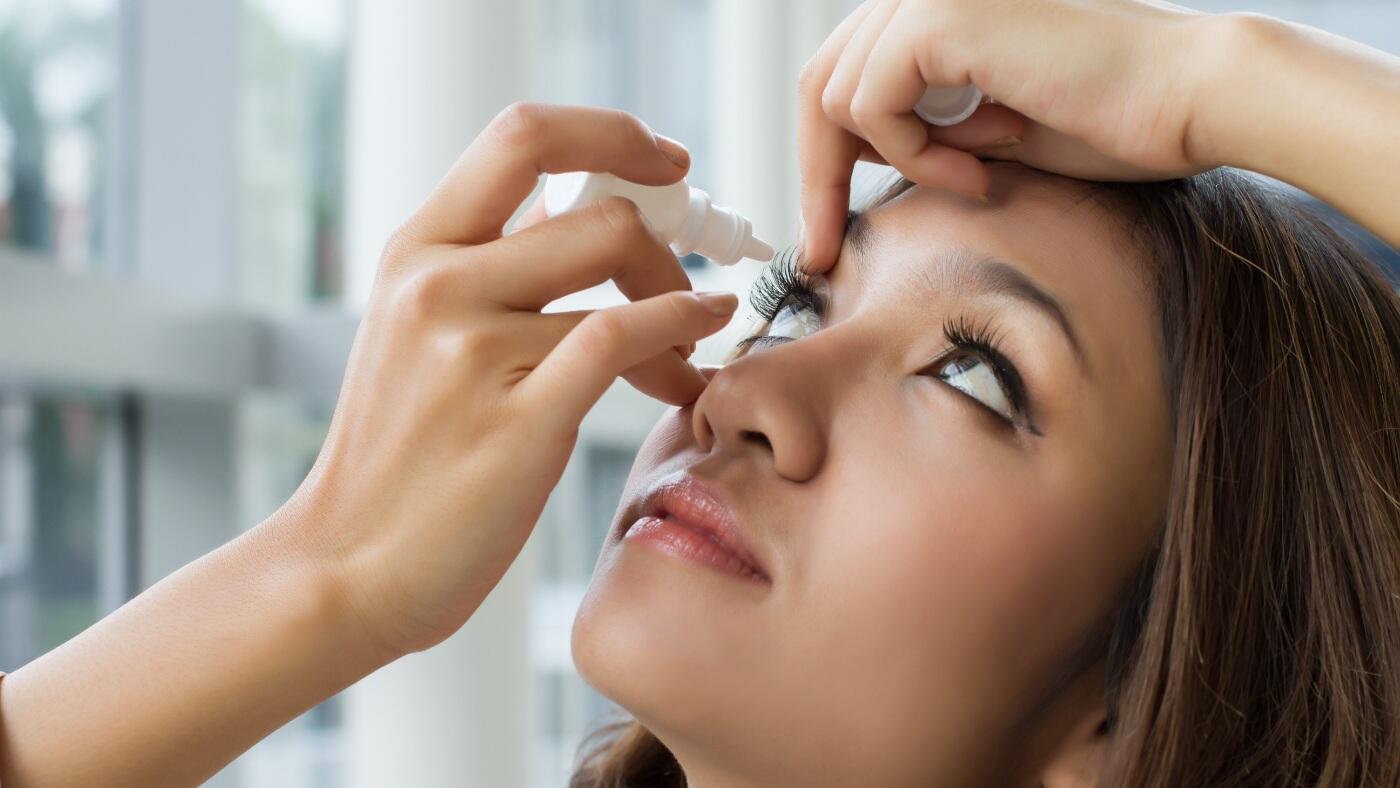 Woman using eye drops