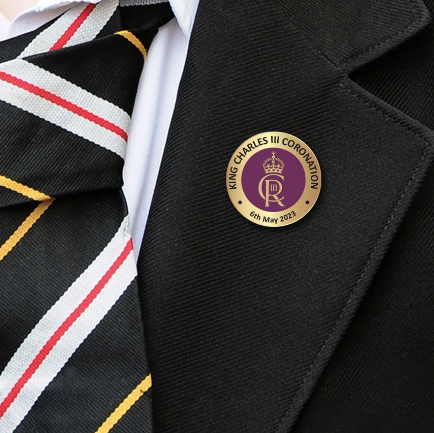 round coronation badge on blazer