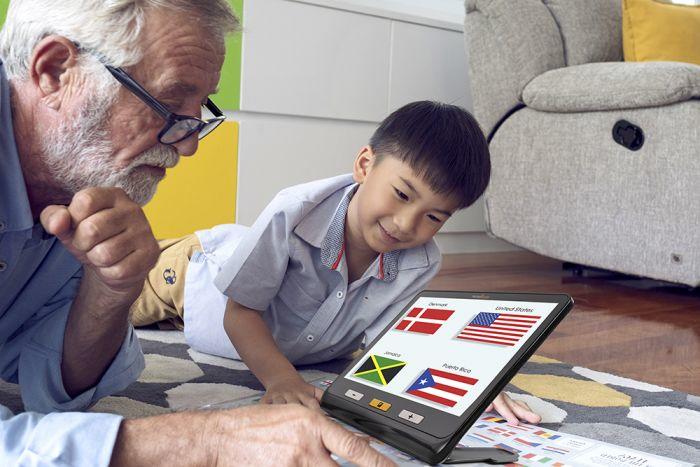 A man and a young boy using the explorē 12 to view images of flags