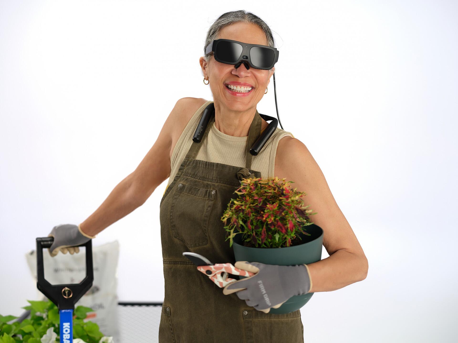 A lady wearing eSight go for gardening