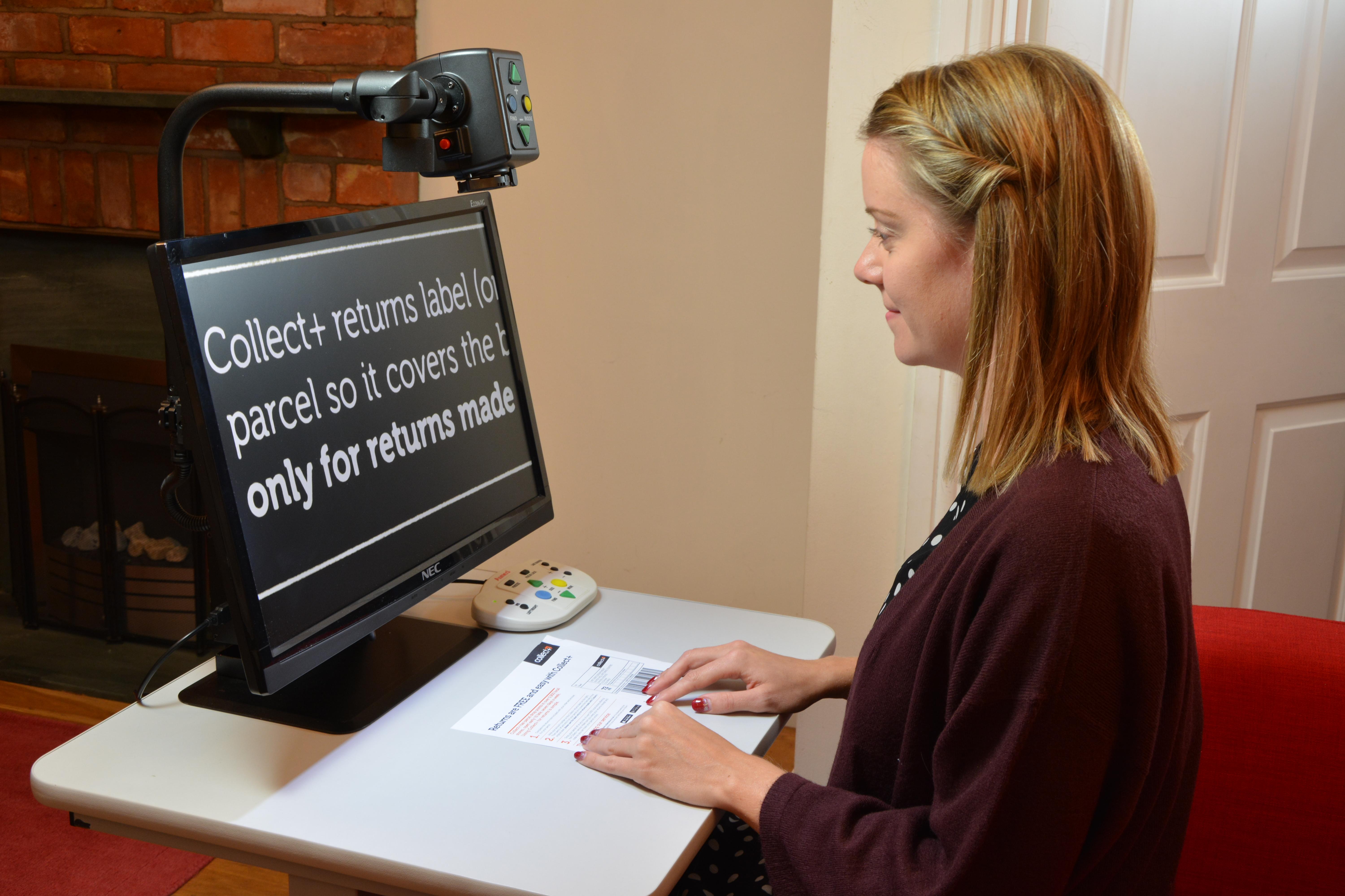 A lady sat using the digimax to read a returns label