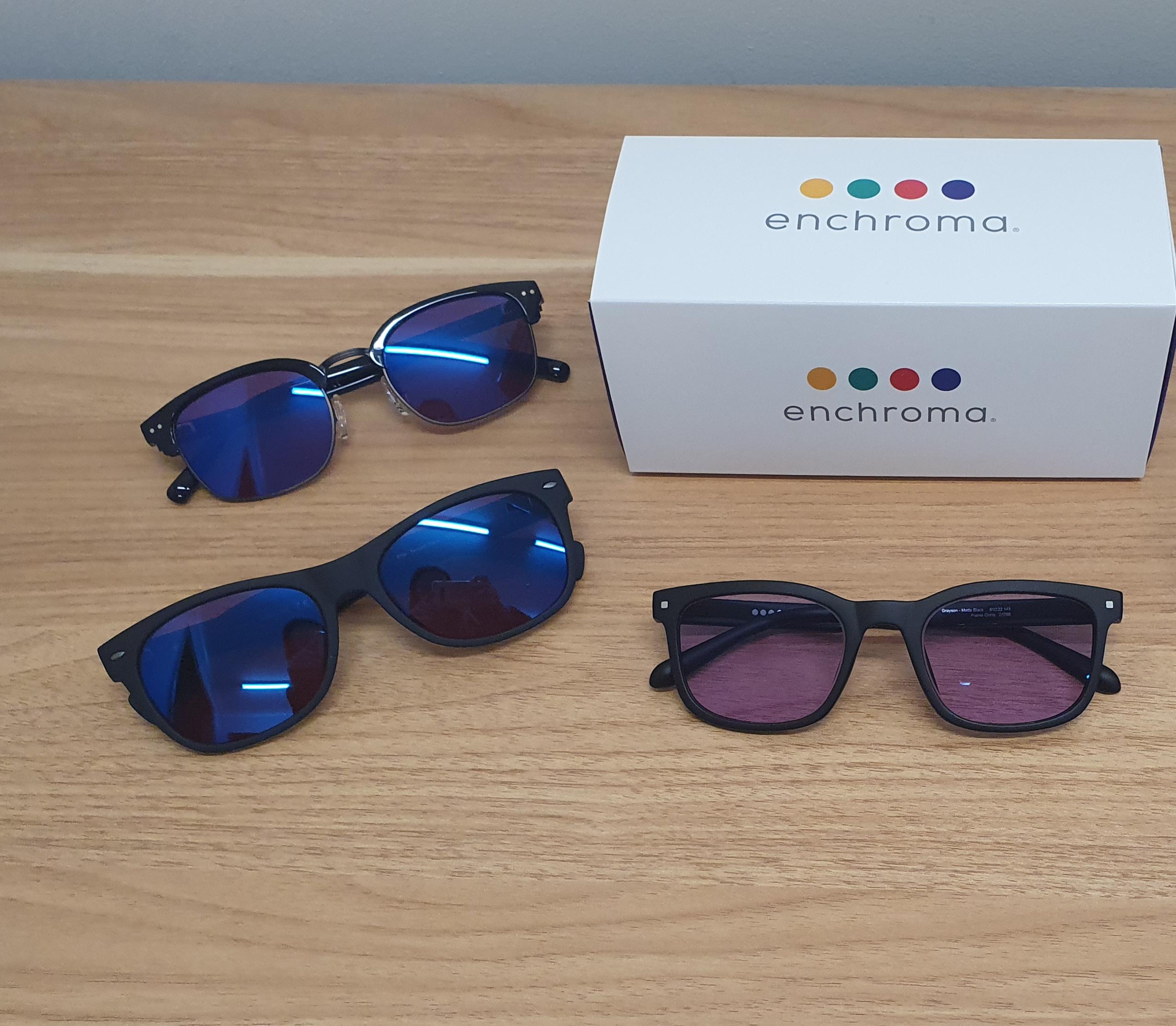 Image of 3 pairs of EnChroma Colour Blindness Glasses with the enchroma presentation box to the side of them