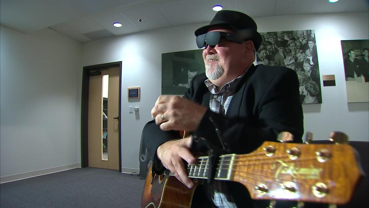 NuEyes Pro worn by a man playing the guitar