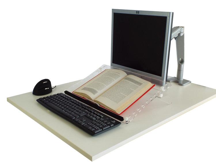 Clear Copy Document Holder on a desk with a book on the Clear Copy. There is also a monitor, keyboard and mouse on the desk.
