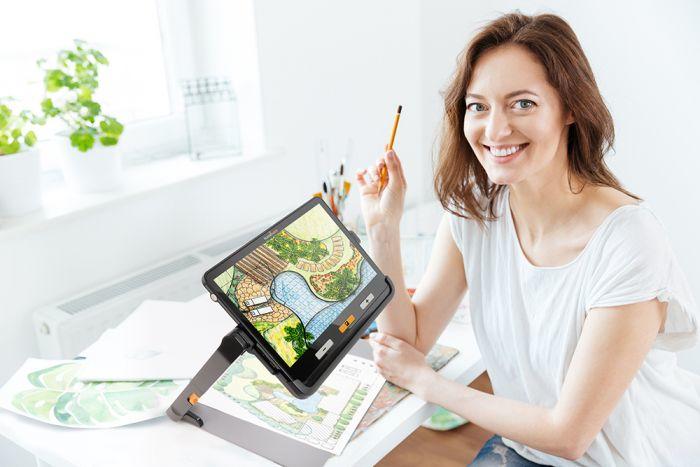 A lady using the explorē 12 to design a garden she is using paints to complete the design