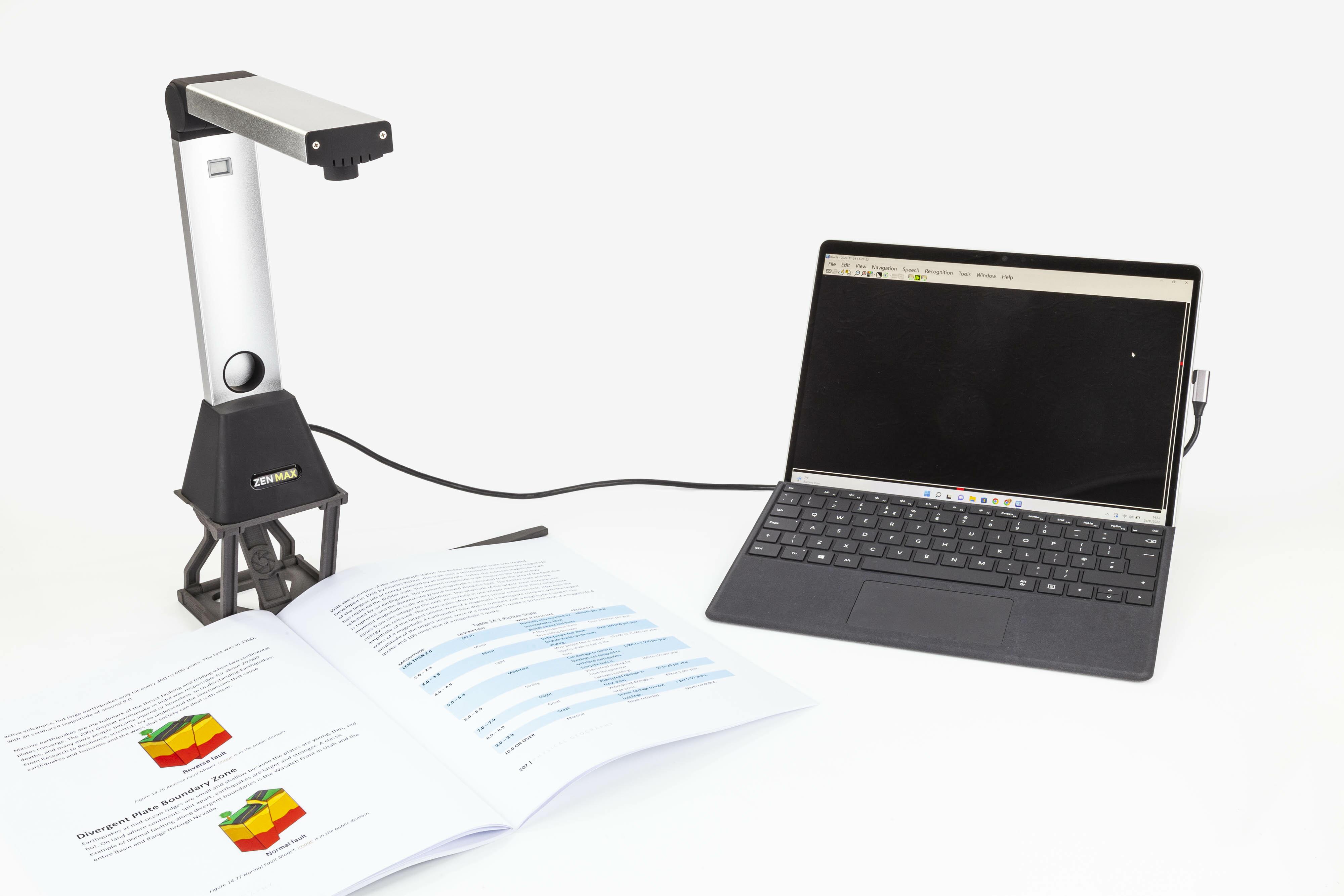 ZEN MAX camera attached to a laptop capturing a large textbook