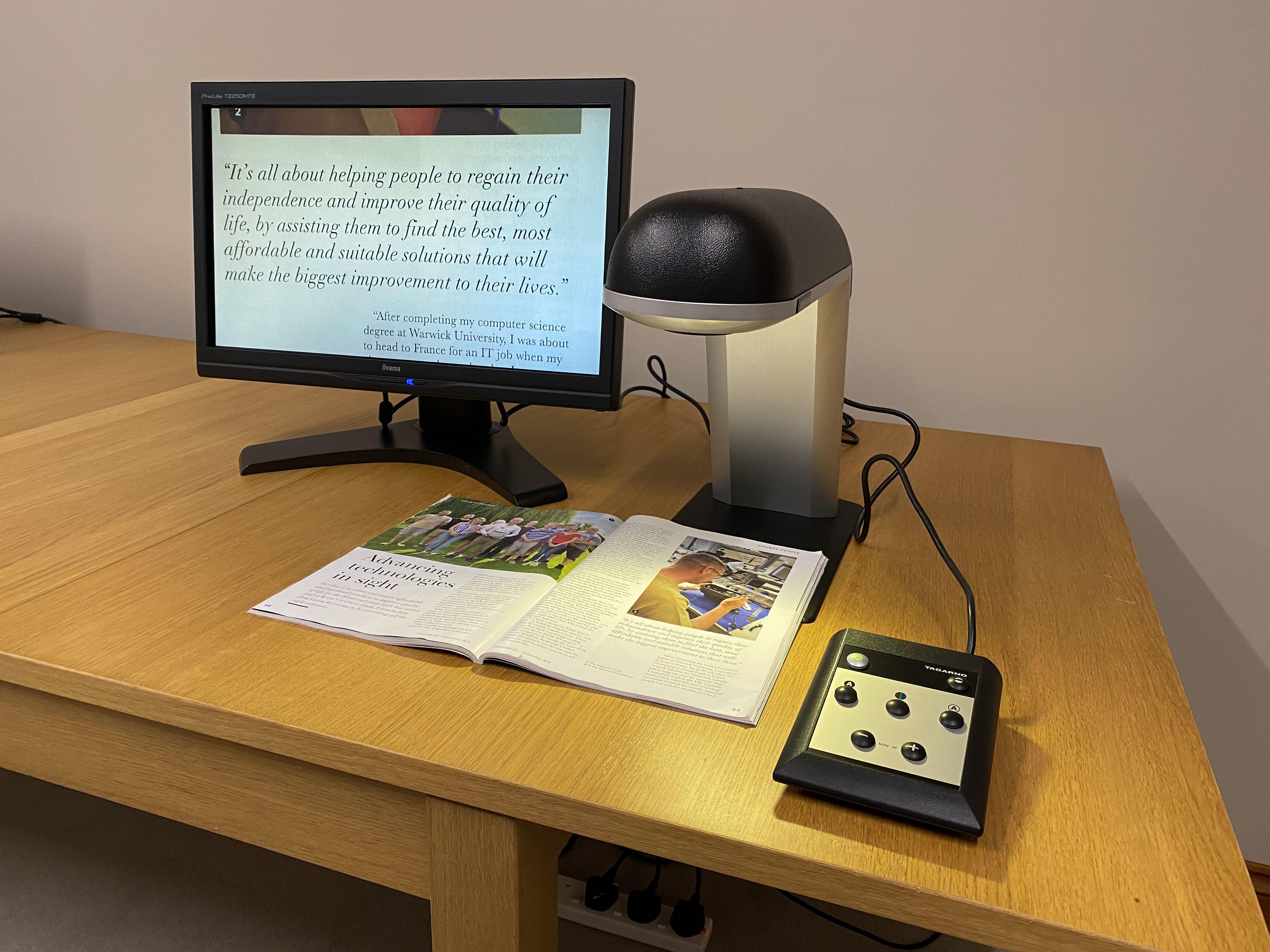 Cobra HD on a desk with a magazine underneath the magazine image can be seen magnified on the connected screen in full colour mode