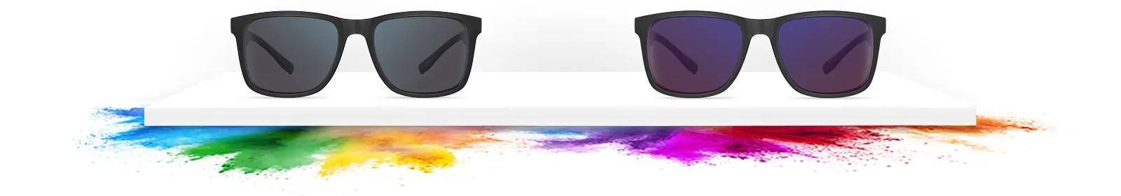 image of two pairs of EnChroma glasses the pair on the left have a colour splash of blue, green, yellow and orange under them, the pair on the right have a colour splash of purple, pink, red and orange under them