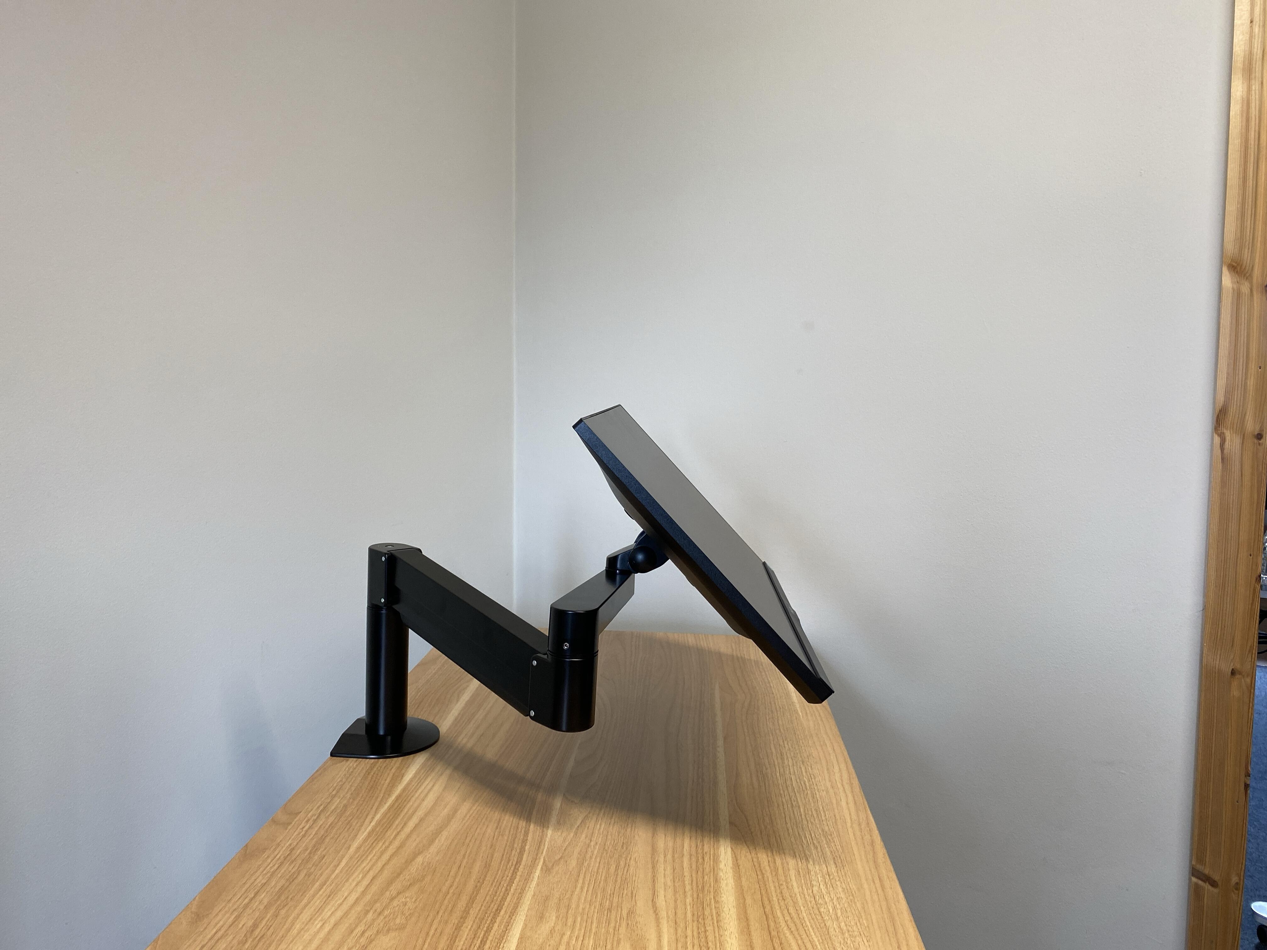 VTArm 3 Gas Assist Monitor Arm positioned with a monitor on, the monitor is positioned at a 45 degree upward angle from the desk