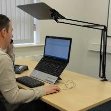 A supervisor blocking unwanted light from above a computer screen