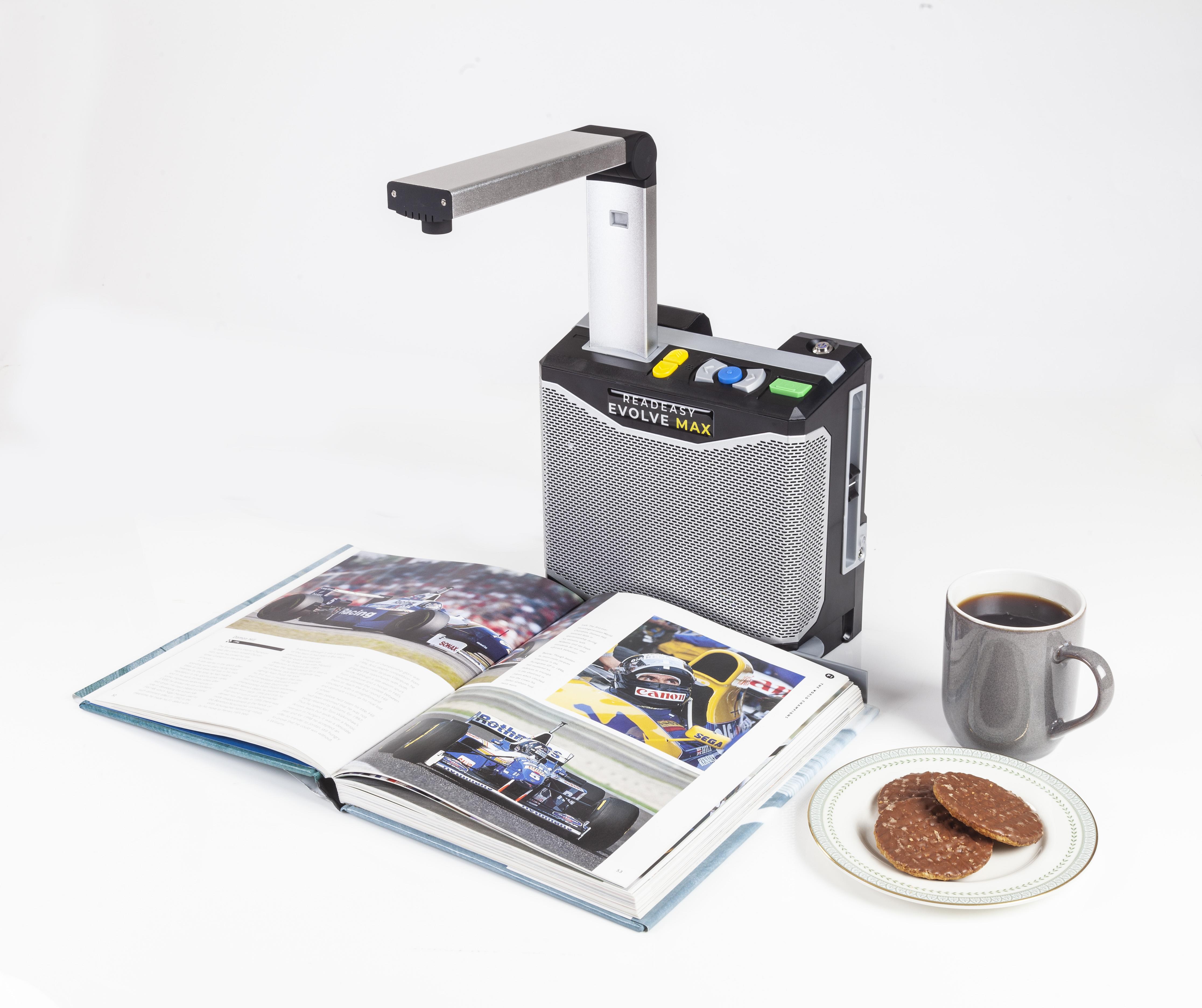 ReadEasy Evolve MAX capturing a page from a Formula 1 book to the right side of the image there is a grey mug filled with black coffee and a place with 3 chocolate covered digestive biscuits