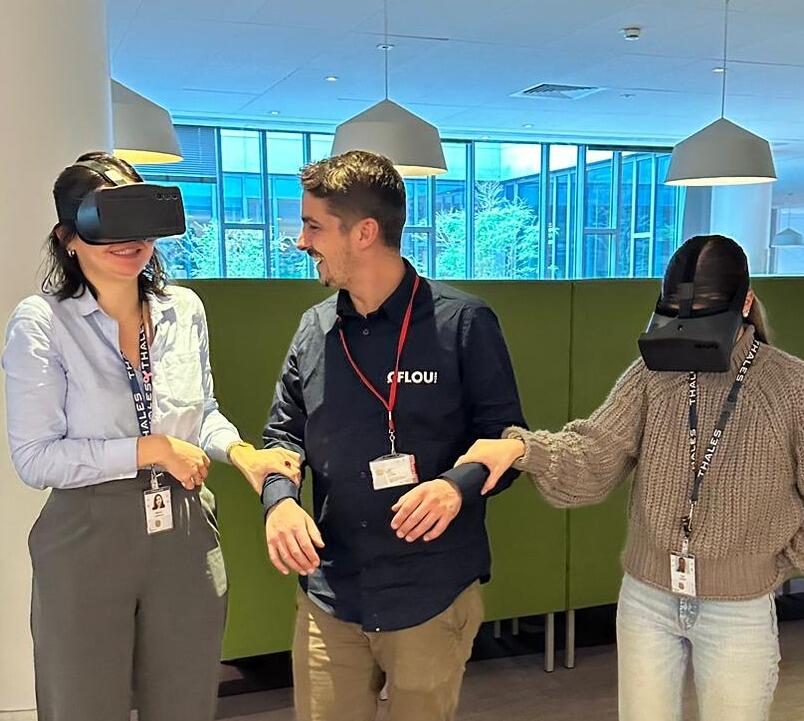 Low Vision Simulator LVS being tried by two ladies a man is between them smiling