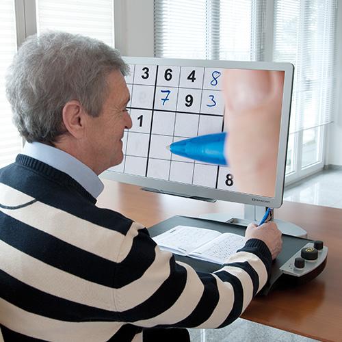 Reinecker VEO Vario Ultra HD being used to magnify a crossword