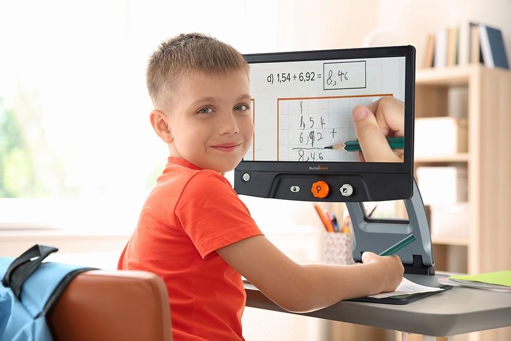 a young boy using the Reveal 16 Full HD digital magnifier