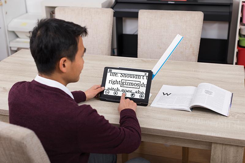 The Compact 10 HD Speech reading a magazine at a table