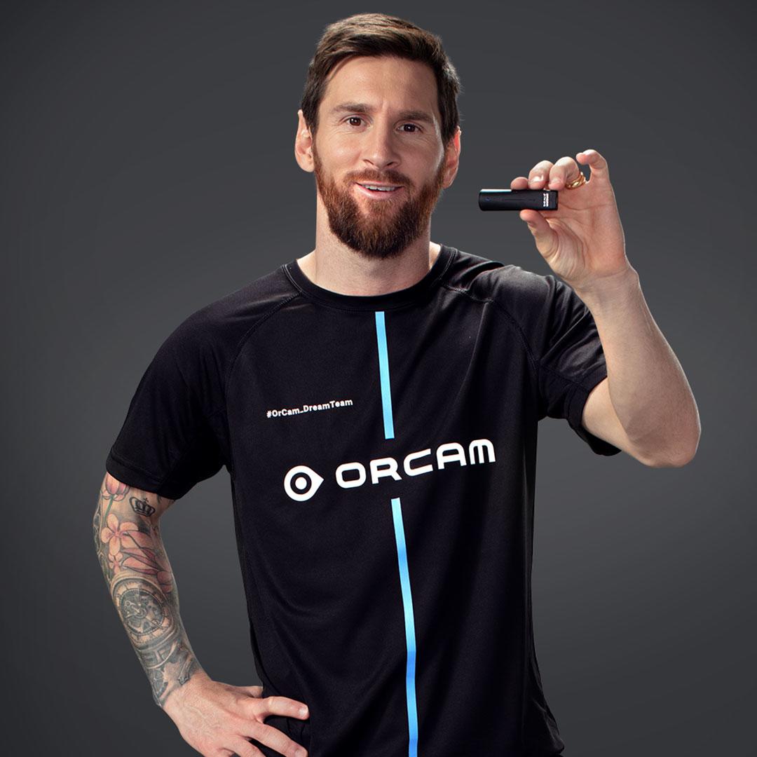 OrCam MyEye Pro being held up by Lionel Messi