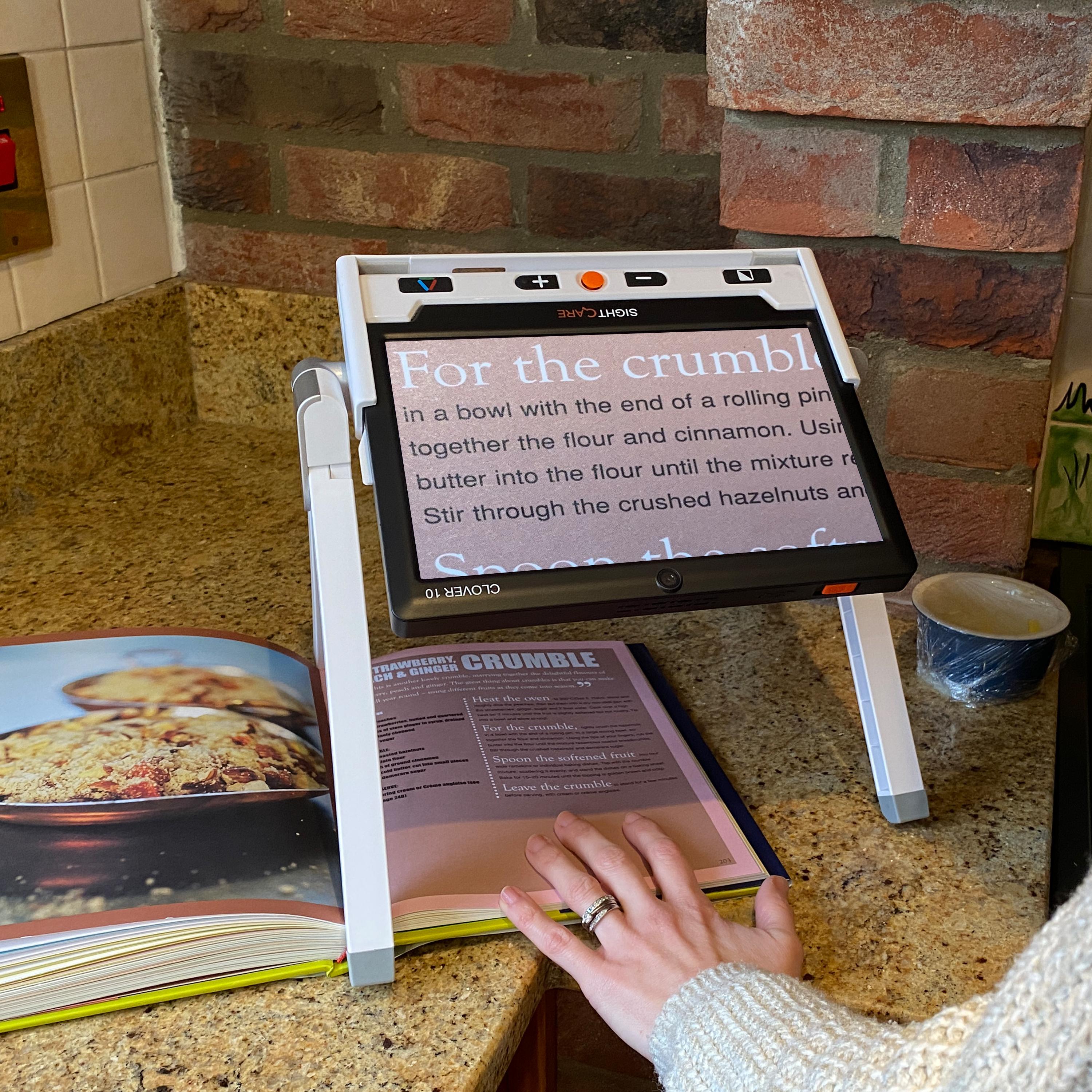 A clover 10 in it's optional stand being used in the kitchen to view a recipe from a magazine
